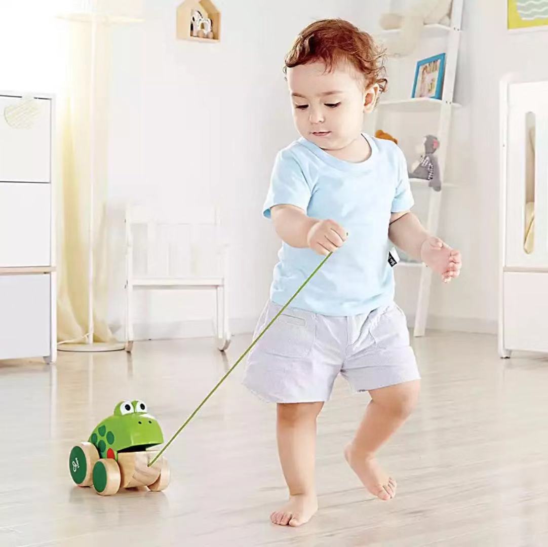 Frog dragging toddler hand-drawn toys